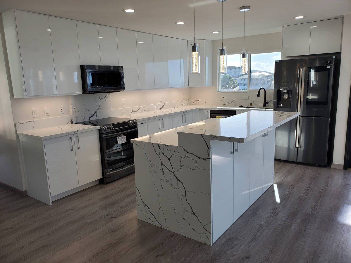 Wide-plank vinyl flooring in a Honolulu kitchen with a quartz island