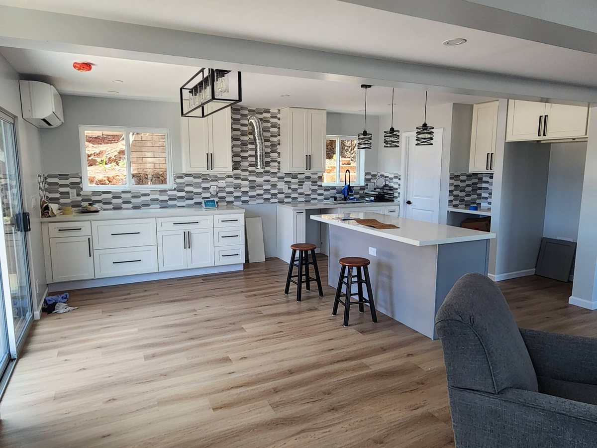 Light vinyl plank flooring in a Leeward kitchen and living area